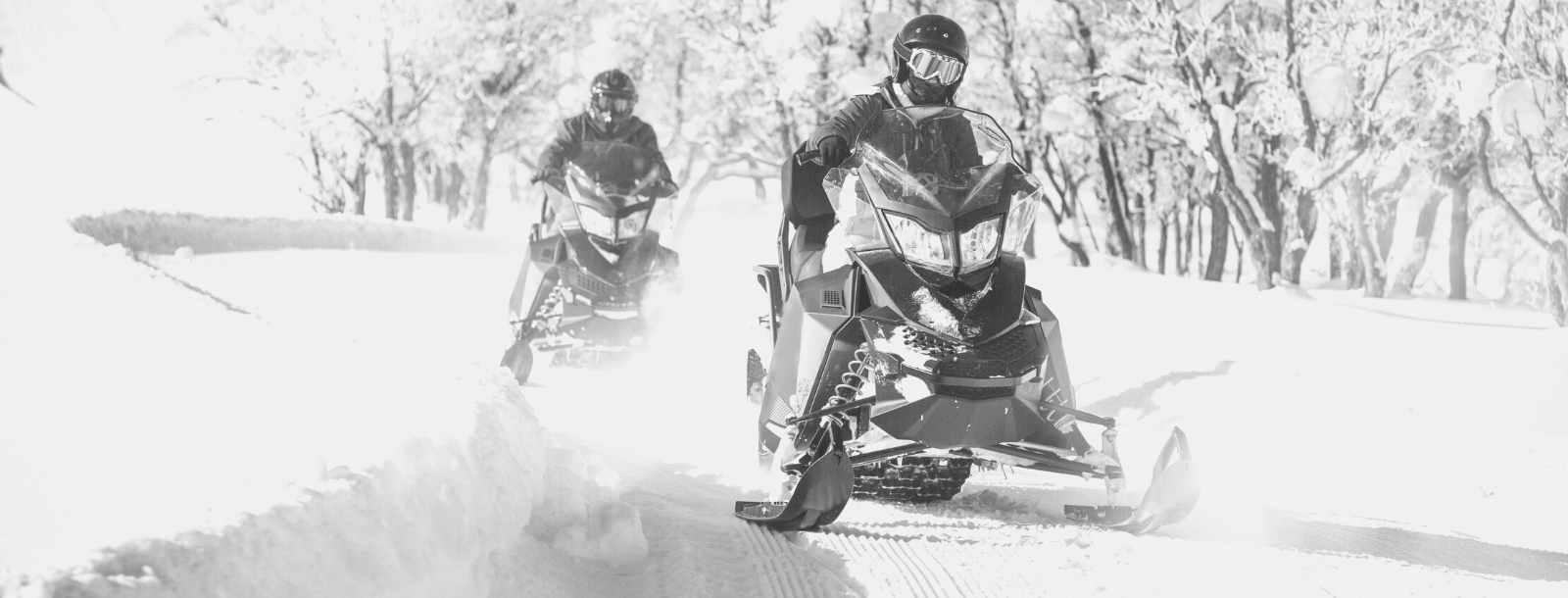 two snowmobiles with riders